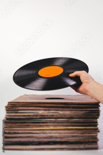 Hand picking vinyl record from stack photo