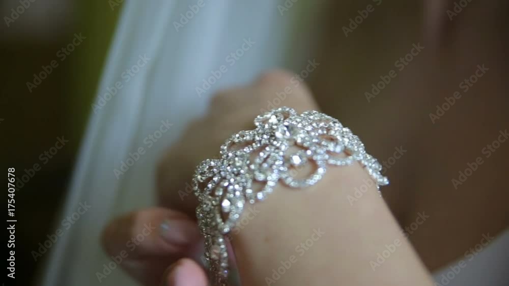 The bride puts the necklace on her arm The bride puts the necklace on her arm
