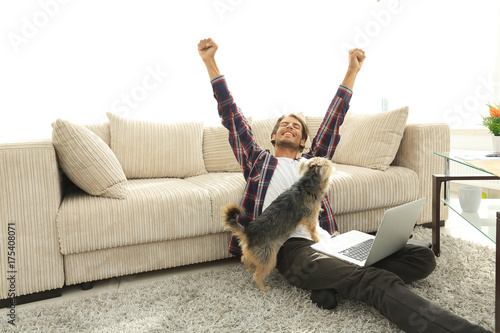 happy guy with his dog sitting in a spacious living room
