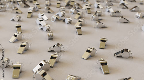 steel whistles scattered on a white surface with shallow depth of field