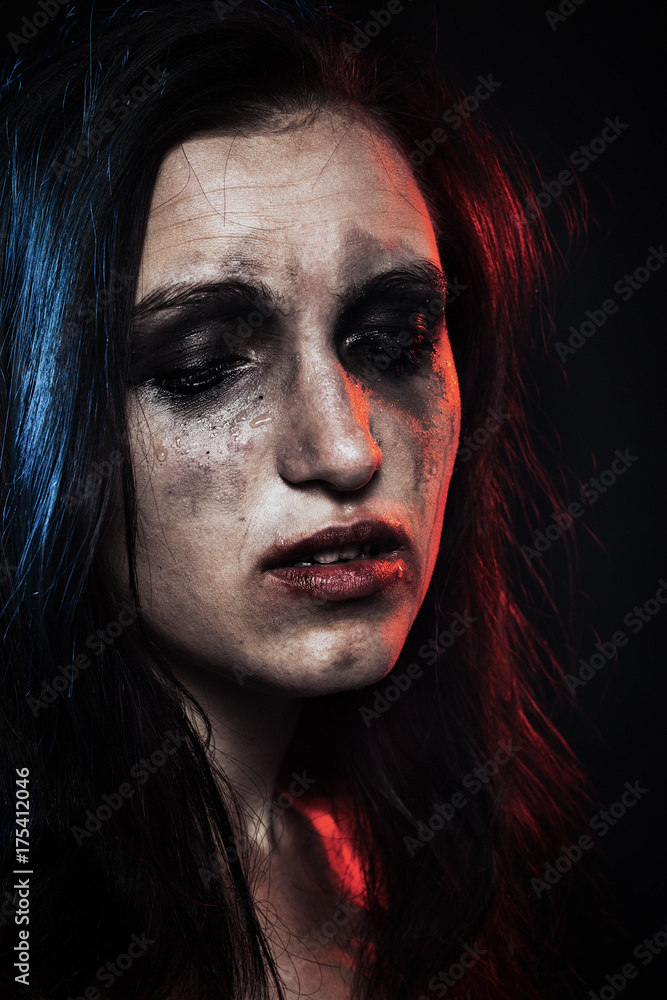 sad woman with smeared cosmetics on dark background