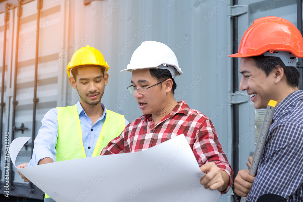 Three Engineer men with safety helmet teamwork building consult project looking paper plan in side construction with level Three Engineer men with safety helmet teamwork building consult project looking paper plan in side construction with level