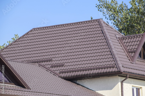 Brown corrugated metal profile roof. The roof of corrugated sheet. Roofing of metal profile wavy shape.
