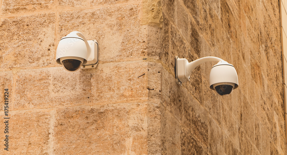 CCTV surveillance camera on a stone wall