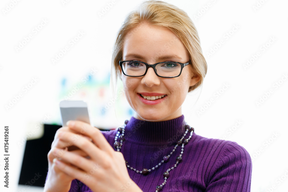 Business woman in office holding mobile phone