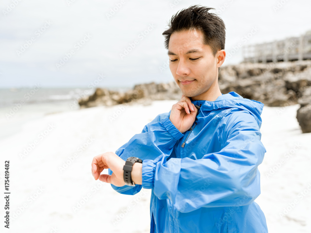 Young man in sportswear using smartwatch Young man in sportswear using smartwatch