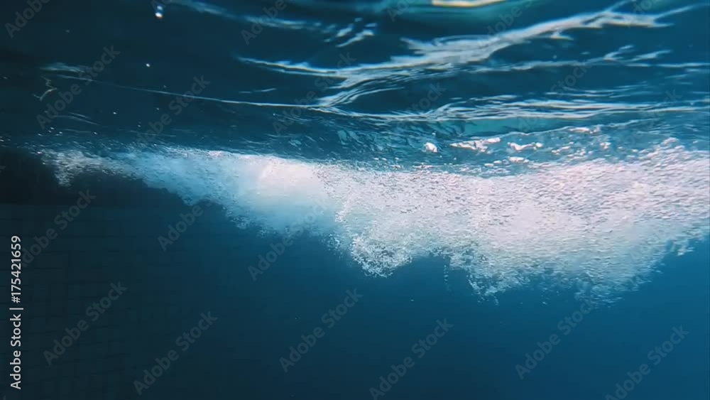 Bubbles in swimming pool underwater slow motion. Deep and blue water natural bubbles shot.