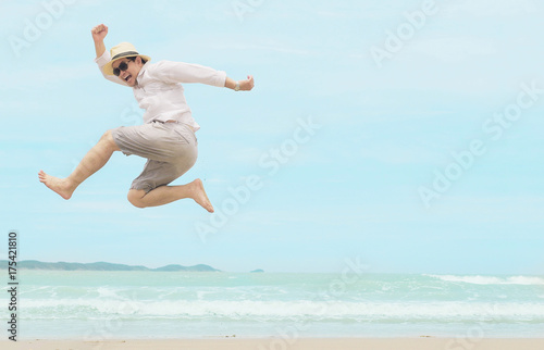 Man jump happy during vacation at sea beach of Thailand