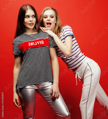 two best friends teenage girls together having fun, posing emotional on red background, besties happy smiling, lifestyle people concept 