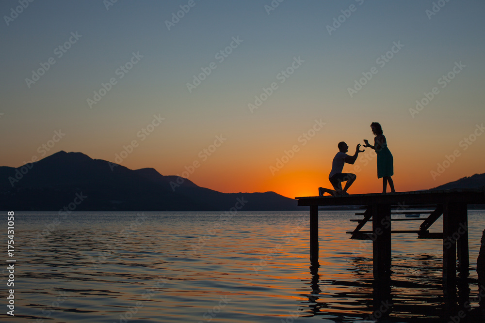Asian love couple sitting on the rock at ocean and sunset view. Couple in love. Fashion. Summer time. Sea.