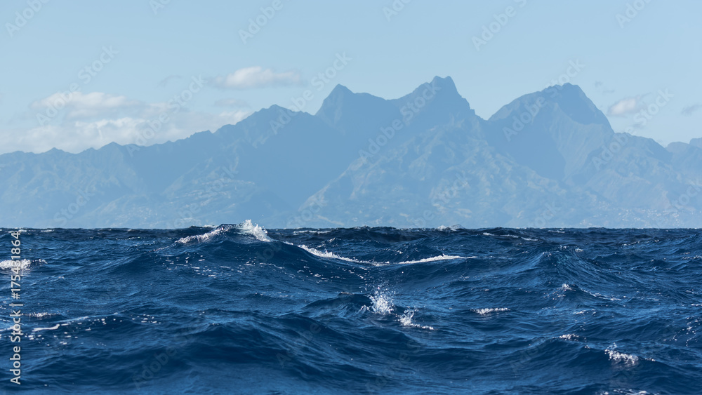 View of Tahiti from the sea in a windy day, foam and waves
