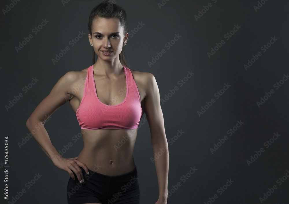 Obraz premium Woman portrait young sport on dark bg studio shot