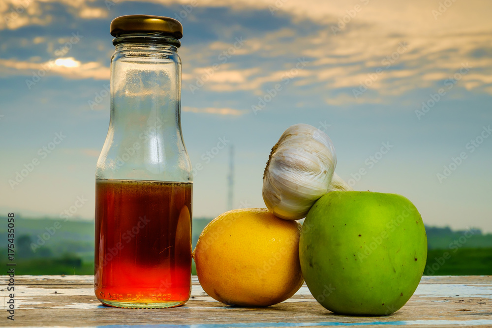Fresh organic honey in glass jar , garlic, lemon and green apple on old wooden with blurred background , healthy nutrition, strengthening immunity and treatment of flu Fresh organic honey in glass jar , garlic, lemon and green apple on old wooden with blurred background , healthy nutrition, strengthening immunity and treatment of flu