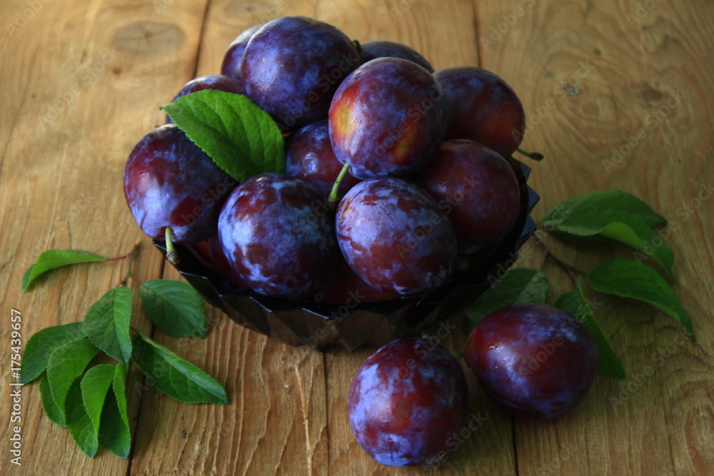 Obraz premium Plums.large ripe plums on wooden table
