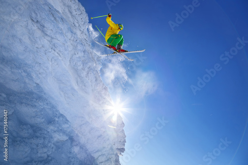 Skier jumping against blue sky from the rock
