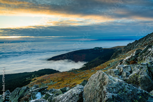 Cloud inversion from a mountain top - beautiful autumn landscape with thick blanket of rolling clouds at sunrise