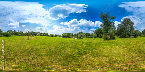 3D spherical panorama with 360 viewing angle. Ready for virtual reality or VR. Full equirectangular projection. Cold blue sky with green grass and with some trees at summer.