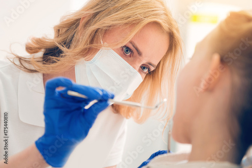 Close up of dental professional examining teeth of patient