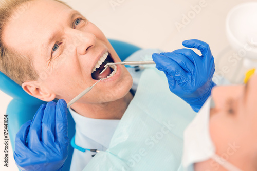 Scaled up look on mature man attending dentist