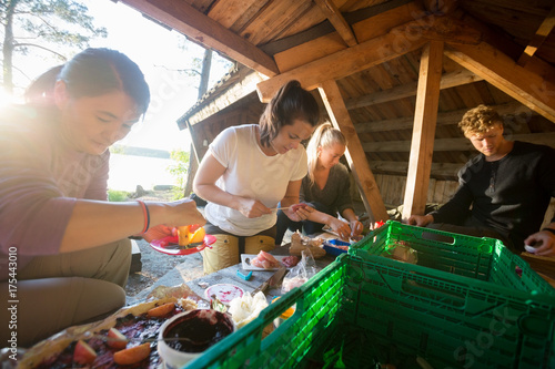 Friends Preparing Food In Shed At Forest