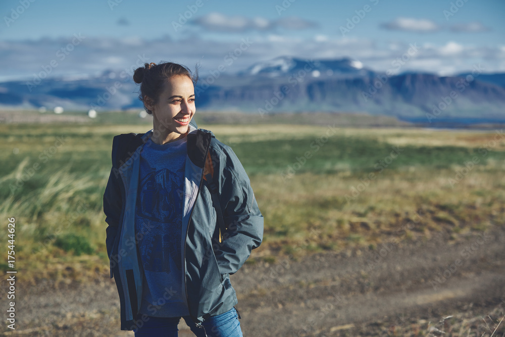 Girl in warm clothing observing surroundings on background of mountains of Iceland. Girl in warm clothing observing surroundings on background of mountains of Iceland.