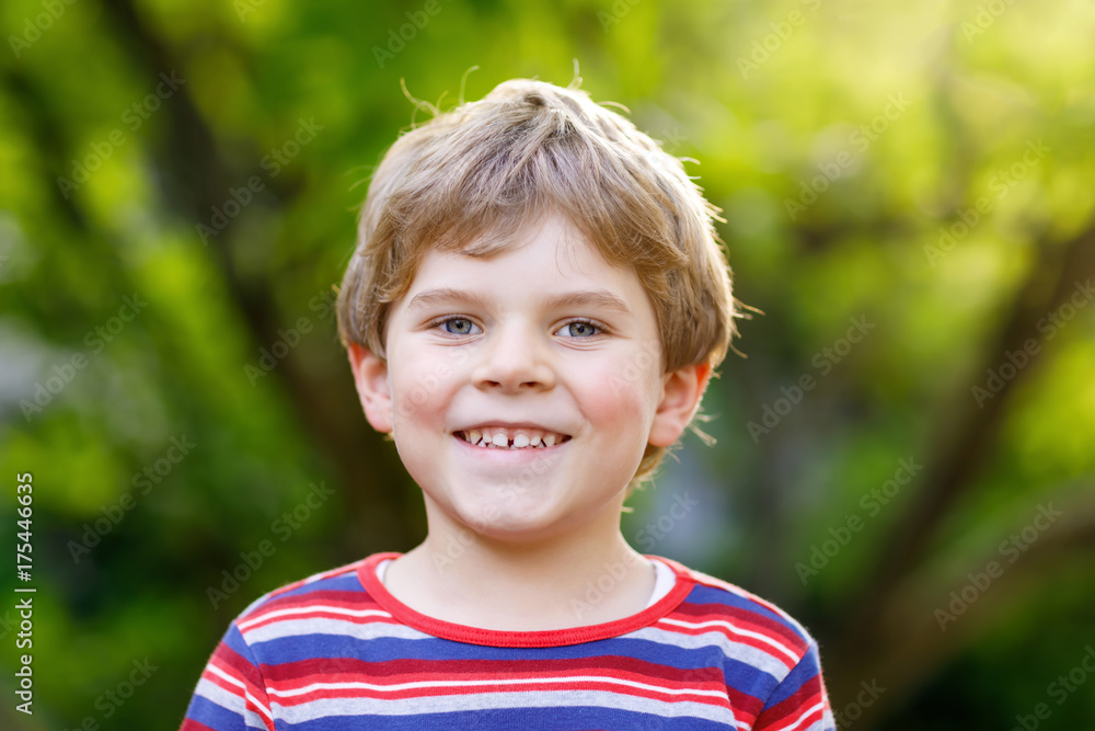 Portrait of beautiful smiling kid boy. Happy child against green tree background Portrait of beautiful smiling kid boy. Happy child against green tree background