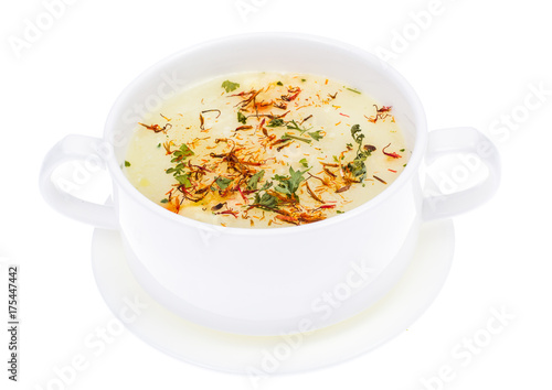 Vegetable soup with saffron in white bowl