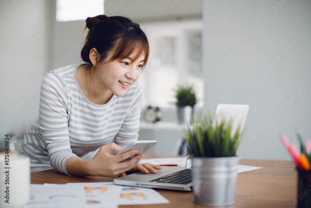 Beautiful young Asia woman working with laptop in living room Beautiful young Asia woman working with laptop in living room