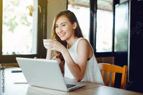 Beautiful Asia woman using laptop and drinking coffee at cafe Free Download Beautiful Asia woman using laptop and drinking coffee at cafe - GFXLoad