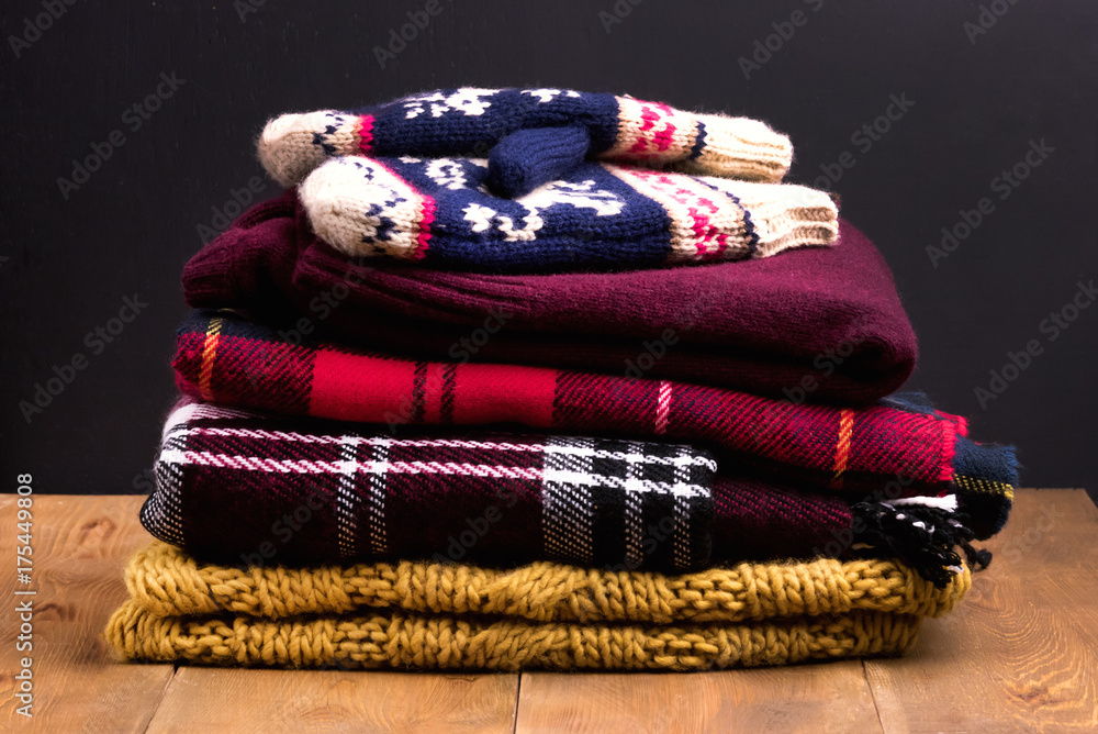 Pile of warm and cozy winter and autumn clothes on wooden background ...