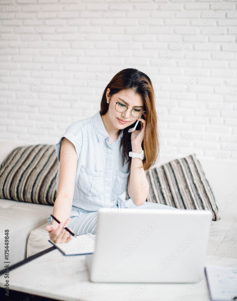 Beautiful young Asia woman working with laptop in living room Beautiful young Asia woman working with laptop in living room