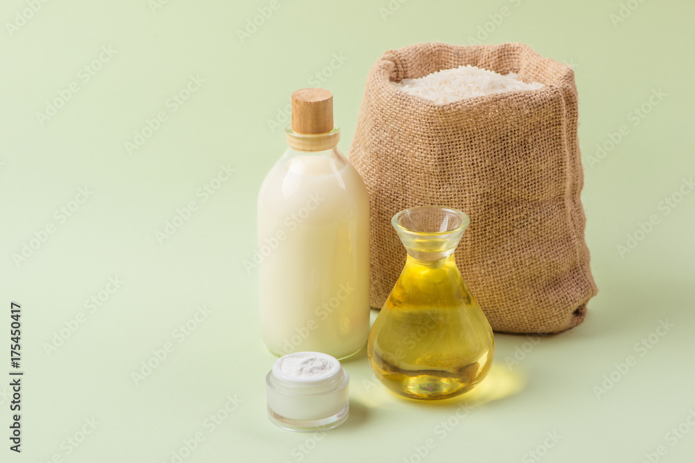 Rice oil in bottle glass and milk over green background. Rice oil in bottle glass and milk over green background.