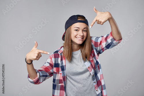 Smiling teen girl pointing at herself cheering happy photo