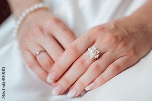 bride Hand with Diamond ring on white dress