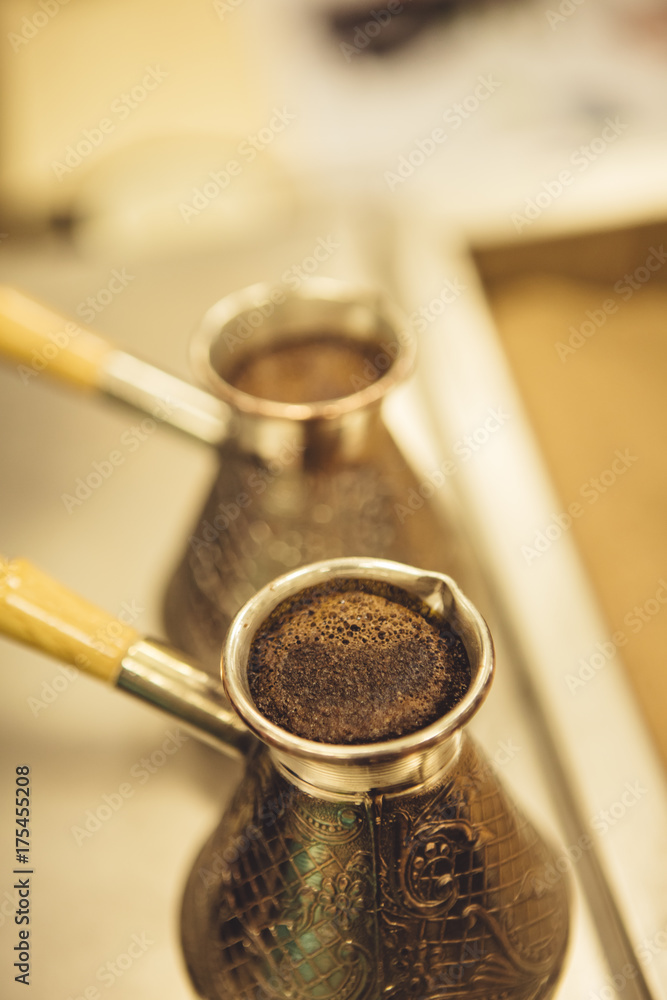 Jezve for coffee brewing placed in the sand in coffee shop. Jezve for coffee brewing placed in the sand in coffee shop.