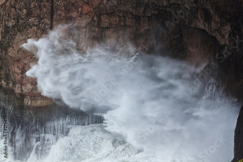 Spray from under the rocks during a storm. Sagres