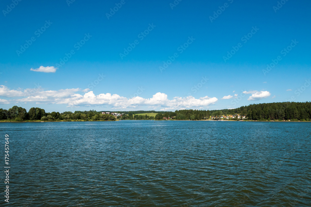 Small town or village in distance behind the lake Small town or village in distance behind the lake