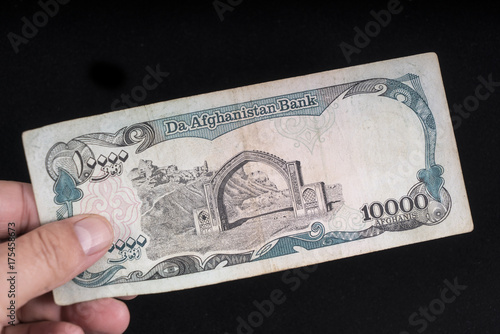 An old 10000 Afghans banknote of Afghanistan on the hand photo