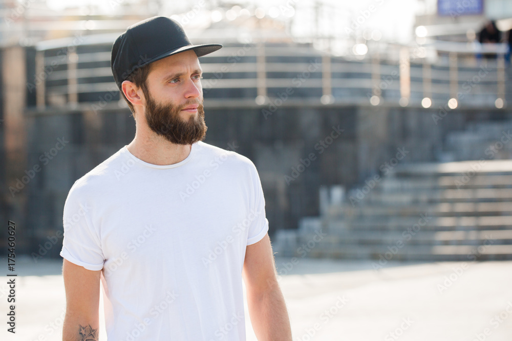 Hipster handsome male model with beard wearing white blank t-shirt with space for your logo or design in casual urban style Hipster handsome male model with beard wearing white blank t-shirt with space for your logo or design in casual urban style