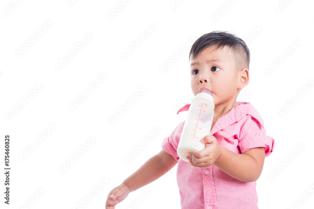 Little asian boy drinking milk from bottle and looking at copy space isolated over white background Little asian boy drinking milk from bottle and looking at copy space isolated over white background