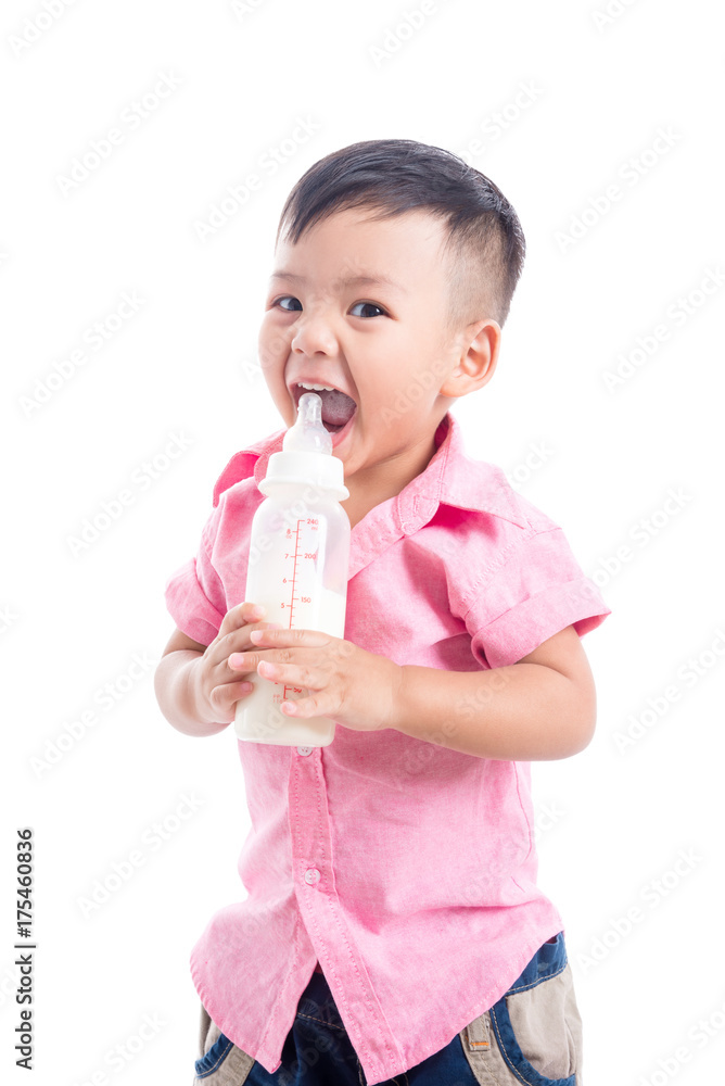 Little asian boy wearing pink shirt holding milk bottle smiling over white background