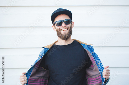 Hipster handsome male model with beard  wearing black blank t-shirt with space for your logo or design in casual urban style