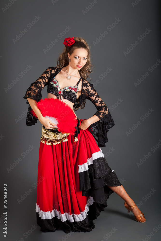 Charming Dancer in Flamenco Costume Poses with Red Fan in Hand