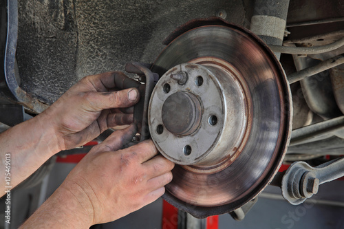 Car mechanic working on disc brakes