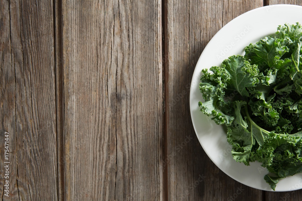 Kale vegetable in plate on wooden table Kale vegetable in plate on wooden table