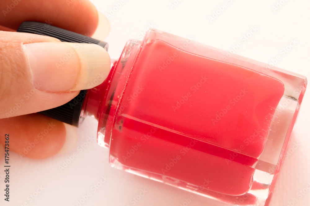 Red nail polish bottle with hand on white background. Stock Photo | Adobe  Stock