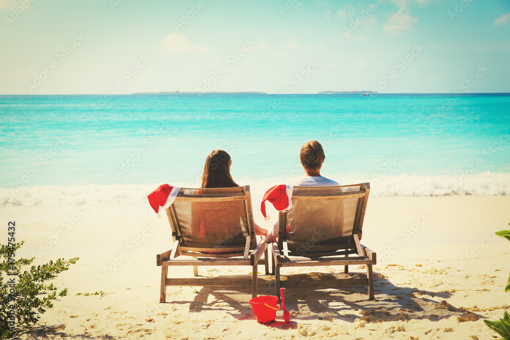Christmas on beach -chair lounges and happy couple at sea