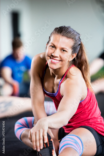 Portrait Of Smiling Woman Doing Stretching Exercise © Tyler Olson