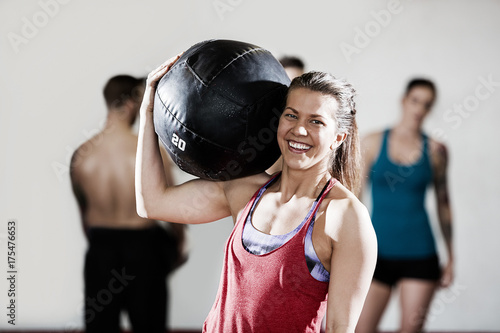 Smiling Female Trainer Carrying Medicine Ball