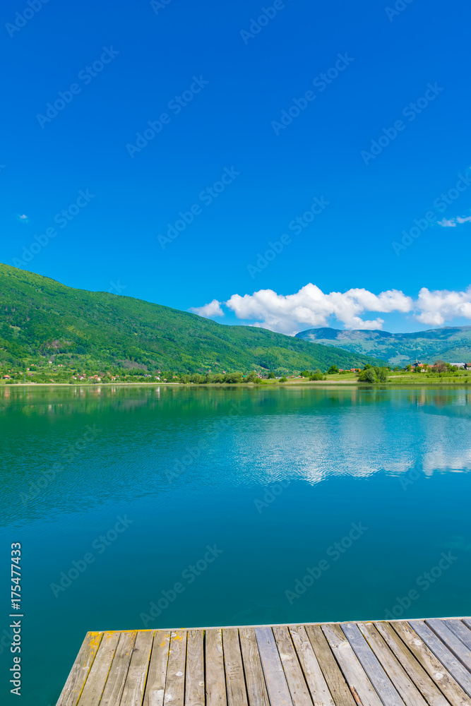 A picturesque mountain lake is located in a valley among the mountains. A picturesque mountain lake is located in a valley among the mountains.